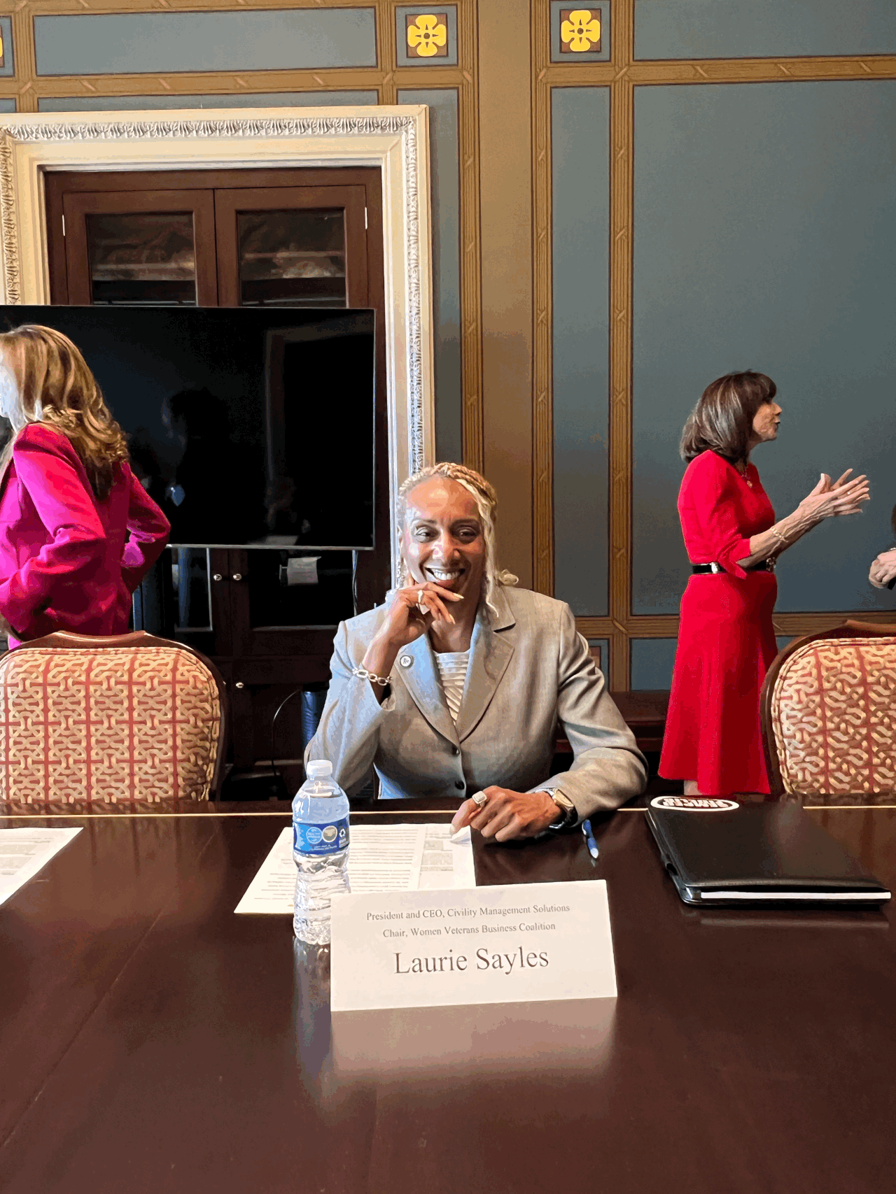 A person sitting at a table with a sign on itDescription automatically generated